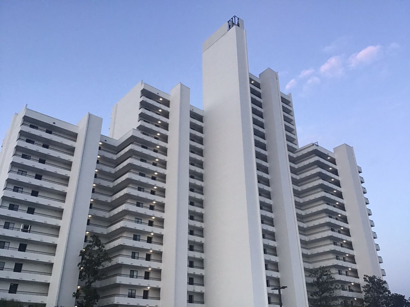 Upward exterior view showing the stepped balconies and tower of One Seagrove Place.
