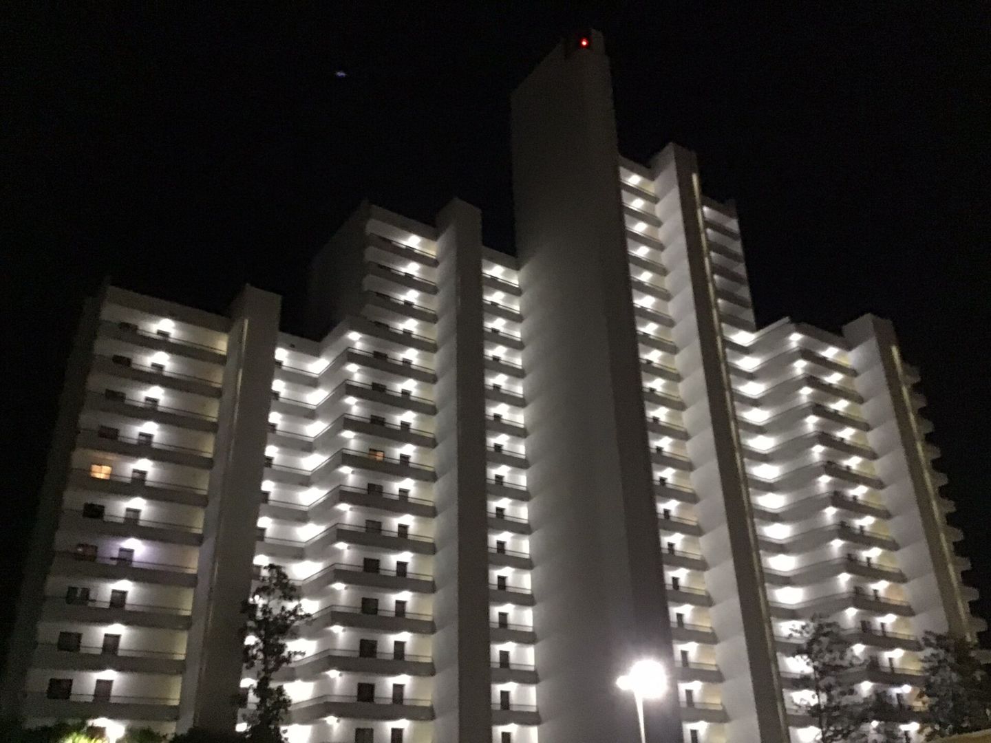 Illuminated exterior balconies of One Seagrove Place at night.