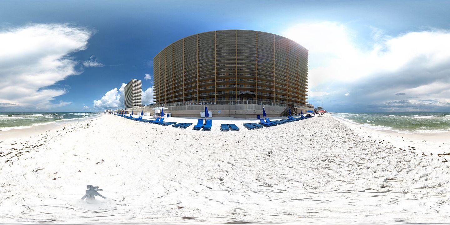 Stitched beach panorama centered on Treasure Island Resort, identified by the original photographer. The panoramic projection distorts the building; the photographer notes stitching artifacts in the water.