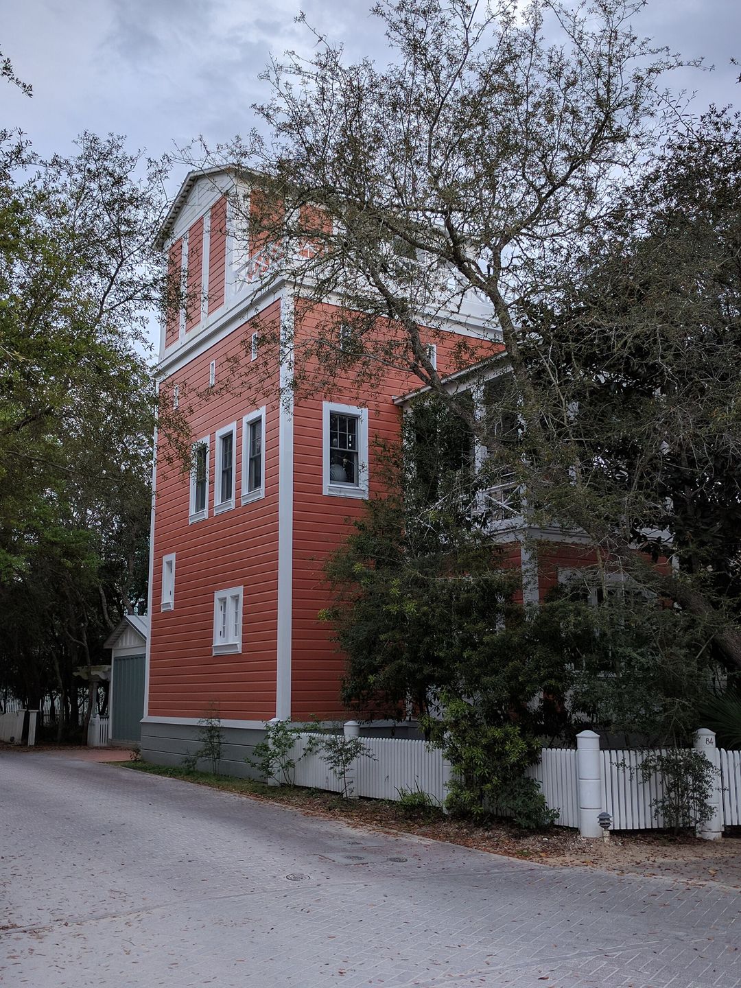 Red-clad multi-story Krier House exterior in Seaside, photographed from the street.